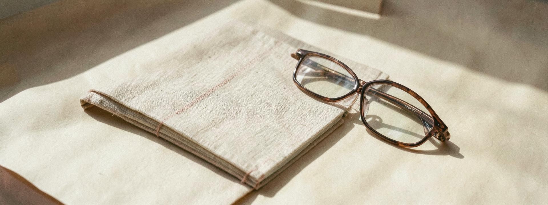 Linen notebook and reading glasses in soft daylight